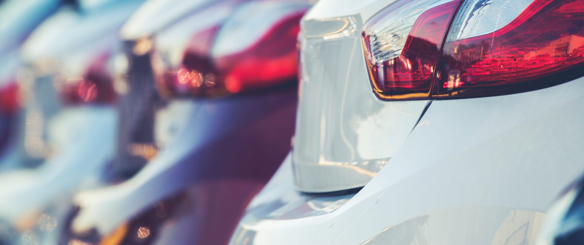 New Cars Production and Sales Concept Photo. Row of Brand New Vehicles For Sale.